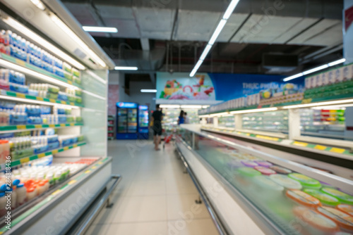 Supermarket blurred background with colorful shelves and unrecognizable customers