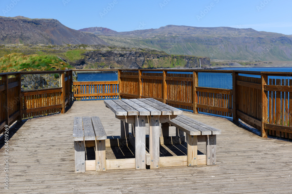 West coast sea cliffs of Snaefellsnes Peninsula on Iceland.Pure blue water with high cliffs above sea. Beautiful colourful scenic view of basalt rock reef.