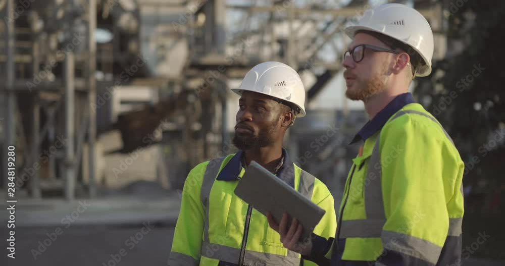 Engineers inspecting oil refinery Engineers inspecting oil refinery
