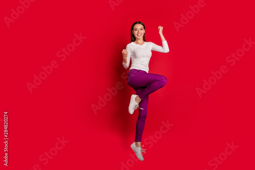 Full length body size photo of nice cute charming fascinating beautiful girlfriend jumping joyfully celebrating her victory while isolated with red background