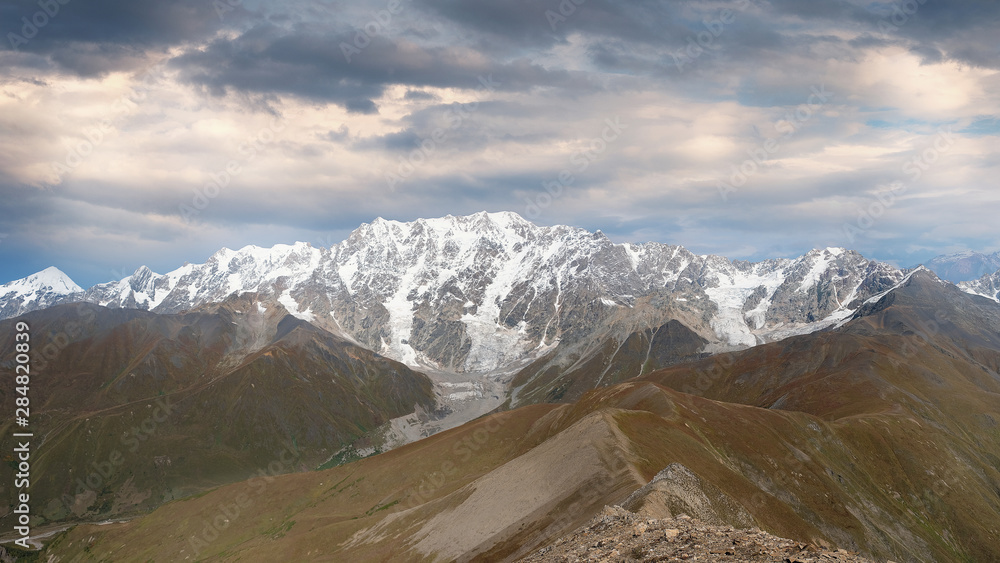  Evening panorama of the snowy peak of Shkhara, over the Caucasian ridge in Georgia mountain Svaneti near the village of Ushguli