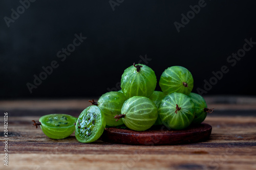 Green gooseberry berries on a wooden table