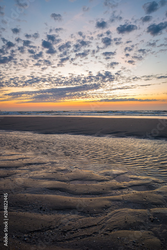 Beautiful clouds and sunset at the North Sea beach of Holland