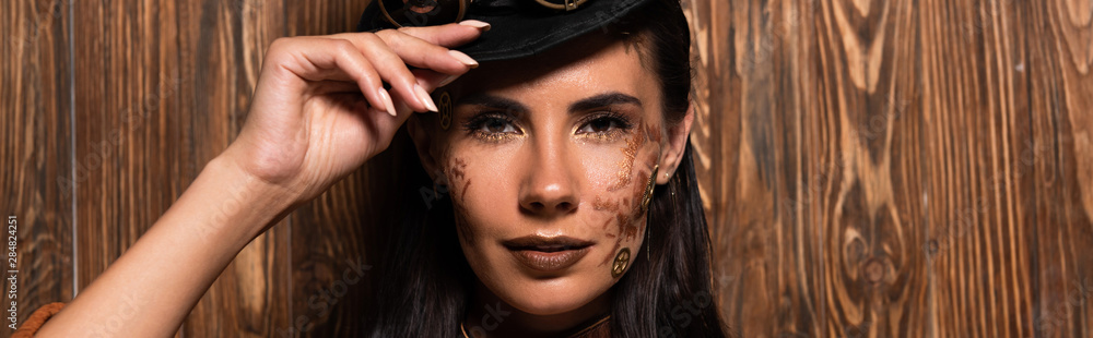 panoramic shot of attractive steampunk woman looking at camera with gently smile on wooden panoramic shot of attractive steampunk woman looking at camera with gently smile on wooden