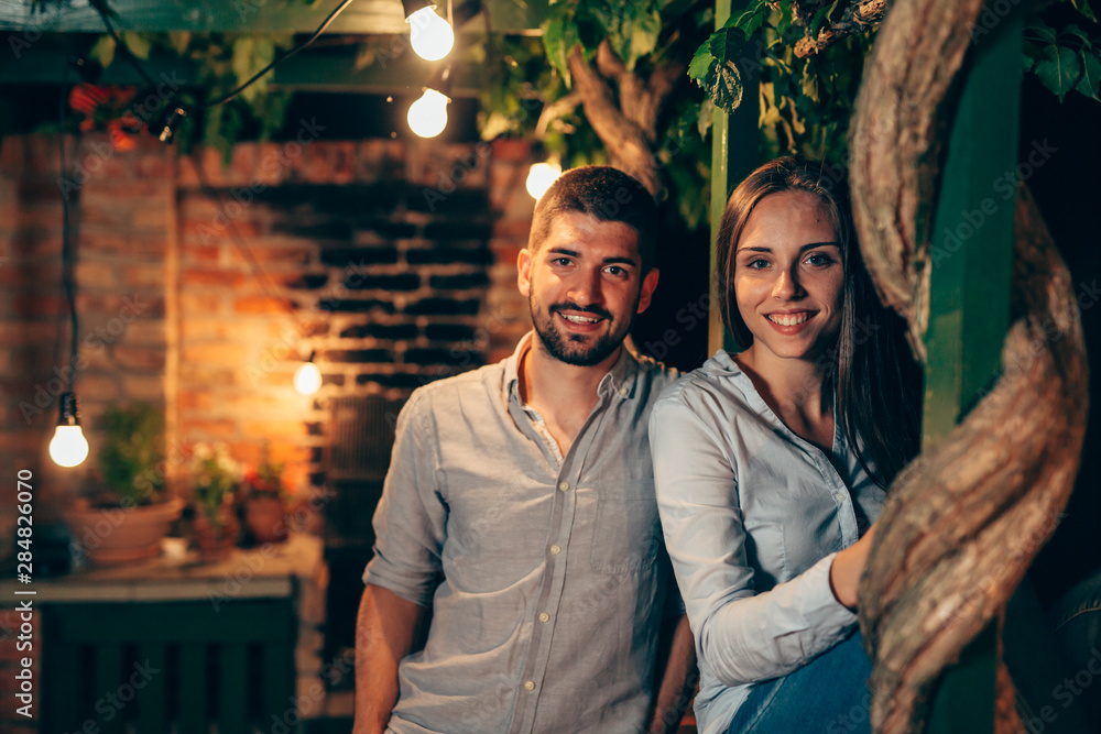 portrait of young happy couple, outdoor posing, moody night scene