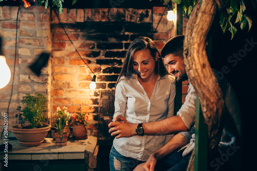 young happy couple using smartphone, outdoor moody night scene