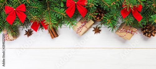 Christmas background with fir tree and gift box on wooden table. Top view with banner copy space for your design