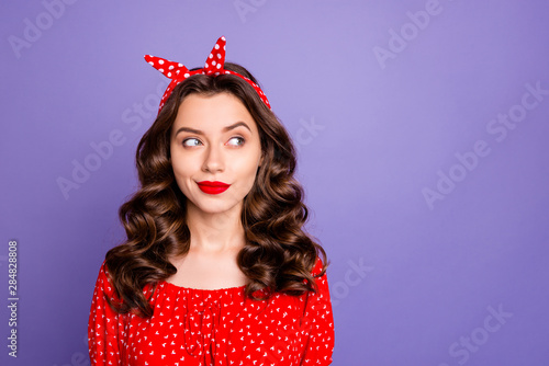 Photo of sly charming girlfriend interested in thing located at emptiness to the left from girl being isolated with violet background