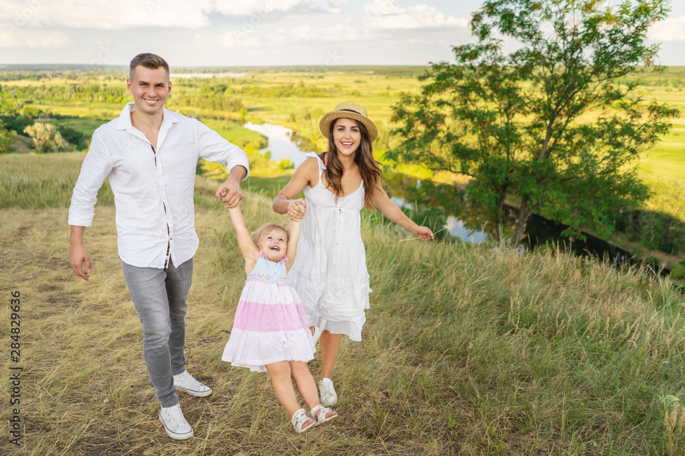 Family bonds. Happy young family of three smiling while spending free time outdoors. enjoying life together Family bonds. Happy young family of three smiling while spending free time outdoors. enjoying life together