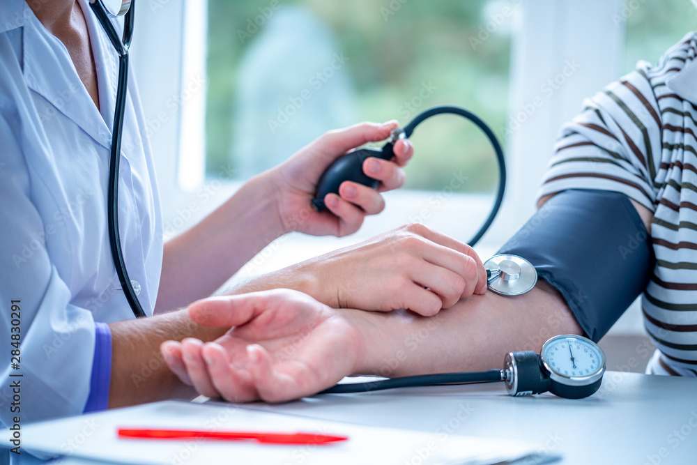 Φωτογραφία Doctor measures the pressure of the patient during a medical examination and consultation in the hospital