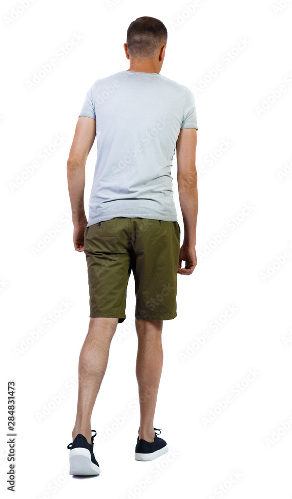 Back view of going handsome man in shorts. Back view of going handsome man in shorts.