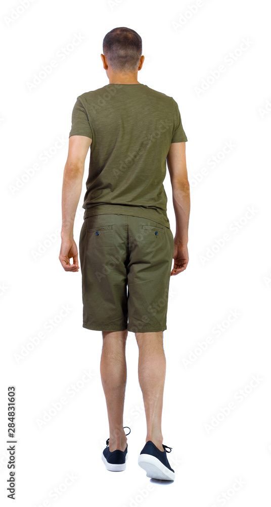 Fototapeta premium Back view of going handsome man in shorts.