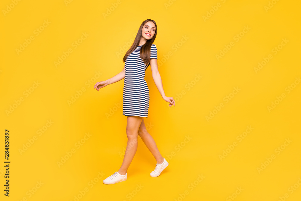 Full body photo of nice girl glad walking favorite park with friends wear striped white blue dress isolated yellow background Full body photo of nice girl glad walking favorite park with friends wear striped white blue dress isolated yellow background