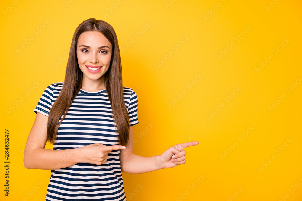 Photo of pretty lady indicating fingers empty space wear striped t-shirt isolated yellow background Photo of pretty lady indicating fingers empty space wear striped t-shirt isolated yellow background