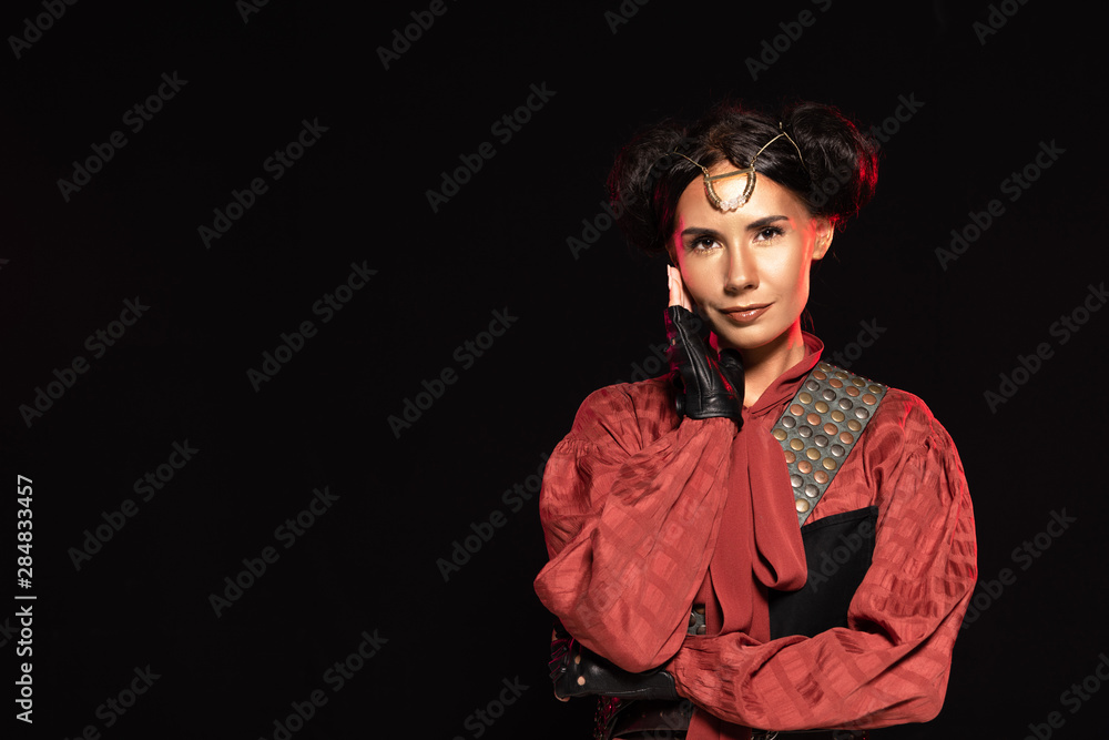 front view of attractive smiling steampunk woman in leather gloves isolated on black front view of attractive smiling steampunk woman in leather gloves isolated on black