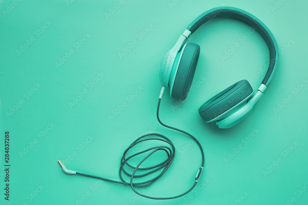 Turquoise headphones on a colored background. Music concept with copyspace. Colored headphones isolated Turquoise headphones on a colored background. Music concept with copyspace. Colored headphones isolated
