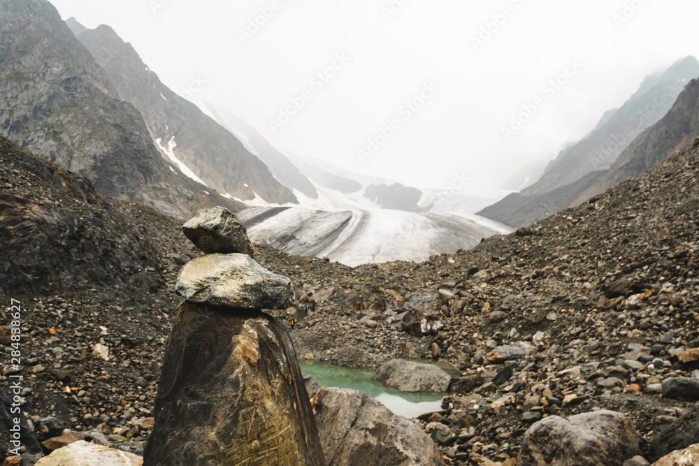 Mountains pyramid at mountains foothills and a cold glacier. A small