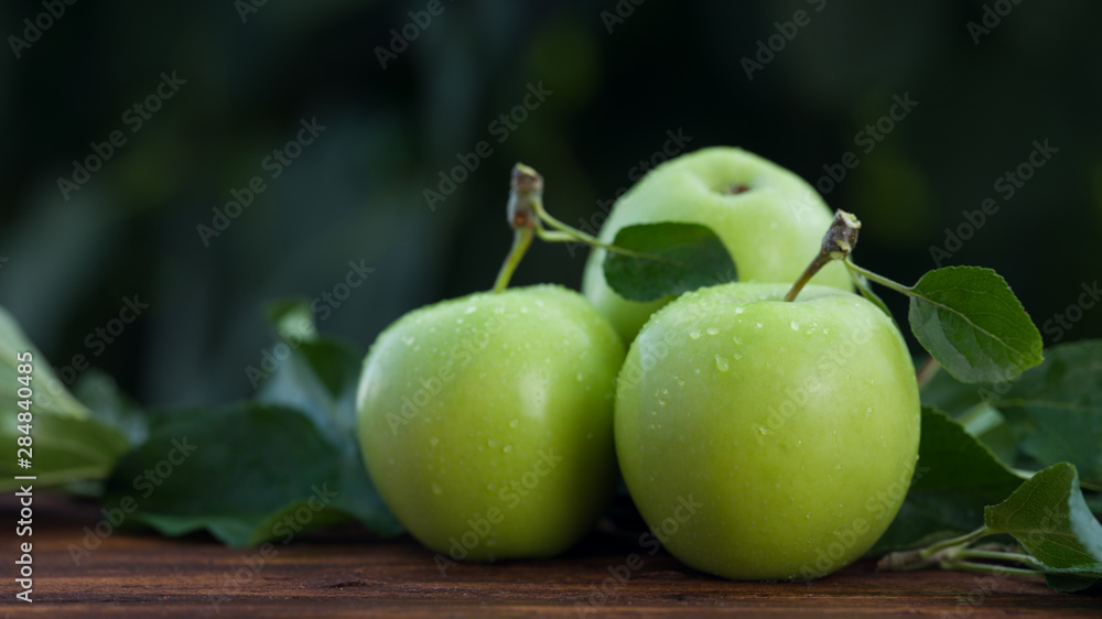 Green apples on table, nature background 