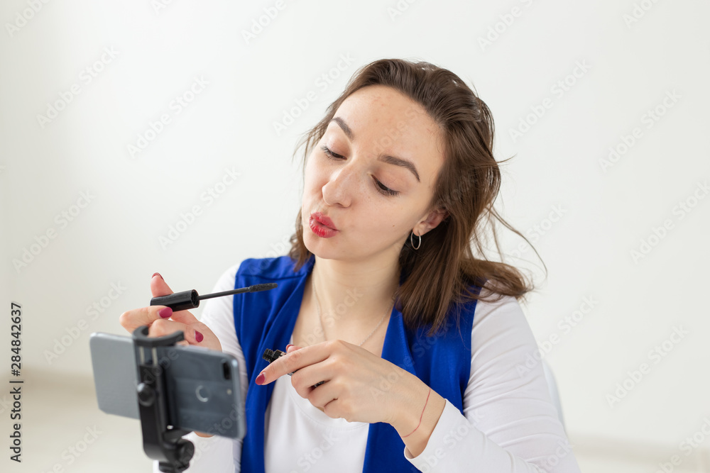 Blogging, broadcast and cosmetics concept - A beauty blogger or video blogger tells and shows her mascara Blogging, broadcast and cosmetics concept - A beauty blogger or video blogger tells and shows her mascara