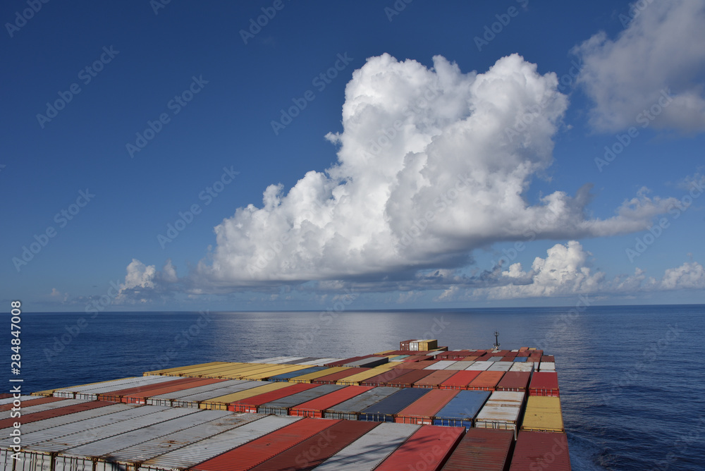 Fully loaded cargo container ship sailing through the ocean. 