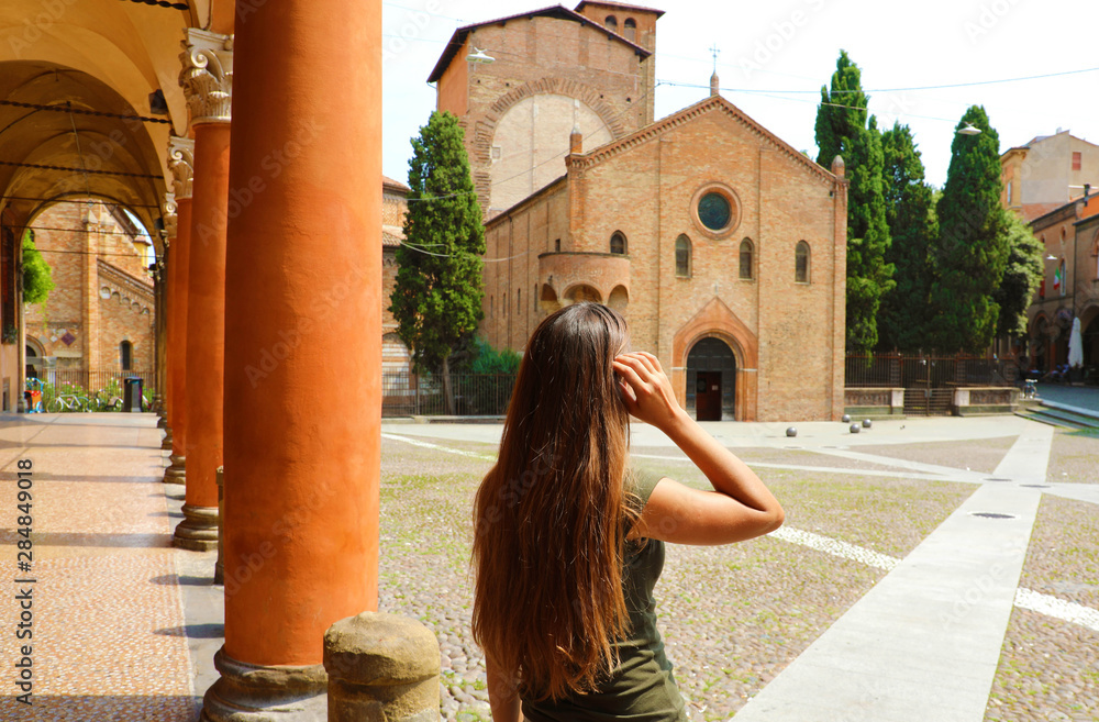 Traveler girl visiting old medieval town in Italy. Woman enjoying beautiful view of Bologna city in Italy.