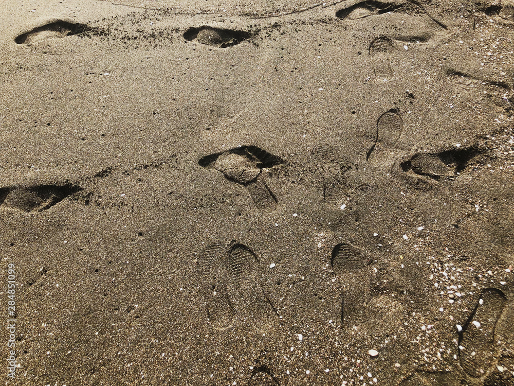 Obraz premium Footprints in the sand. Summer sunny day, sandy background