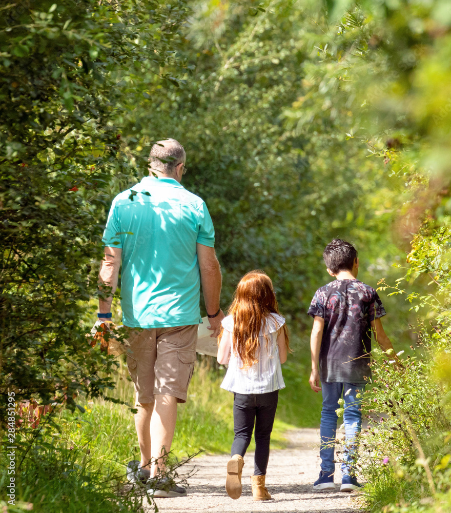 Man taking his children on a nature walk Man taking his children on a nature walk