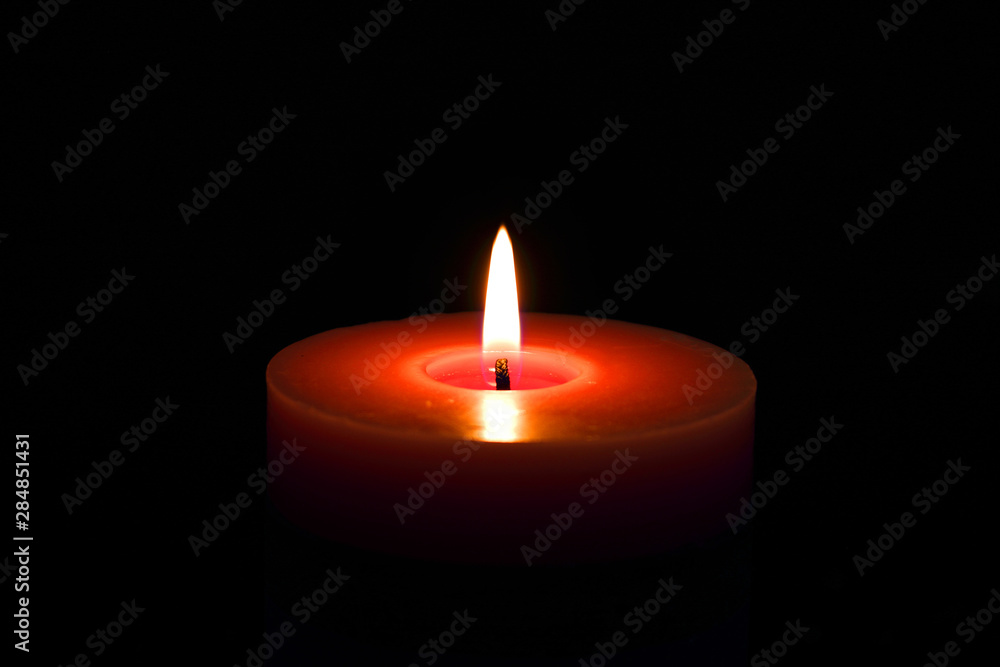 Single candle red flame isolated on black with selective focus Single candle red flame isolated on black with selective focus