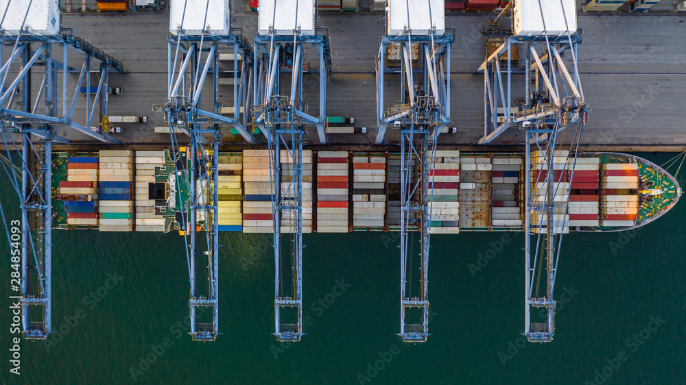 Container ship loading and unloading in deep sea port, Aerial top view of business logistic import and  export freight  transportation by container ship in open sea.