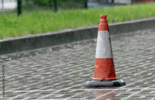 white-orange road cone on a rainy day