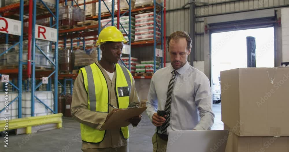 Male warehouse manager and warehouse worker in loading bay 4k