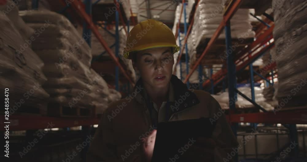 Female warehouse worker patrolling warehouse corridor at night 4k Female warehouse worker patrolling warehouse corridor at night 4k