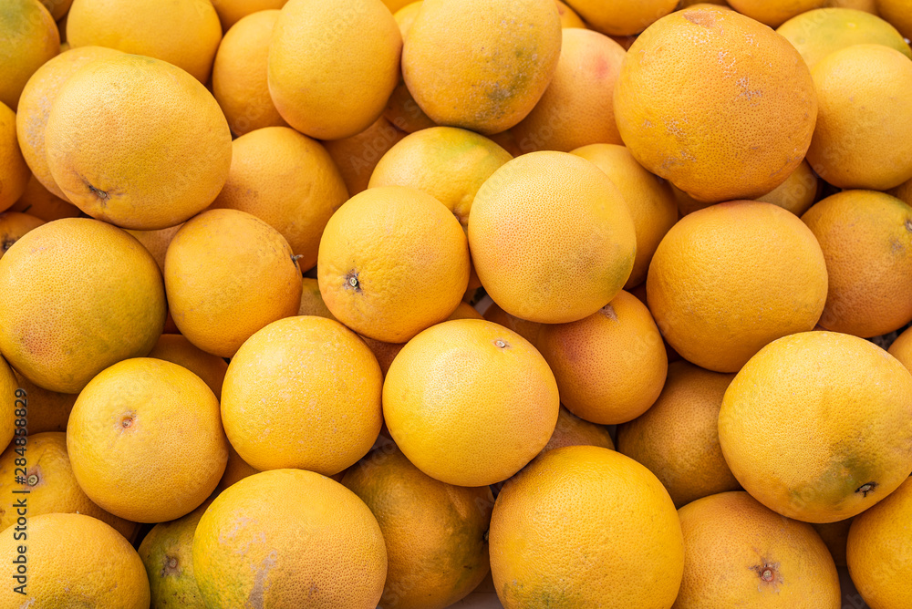 Food Background of ripe organic yellow grapefruits on spanish weekly market.