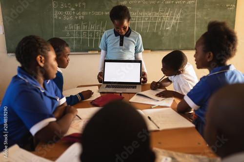 Young schoolboy with laptop at the front of class photo
