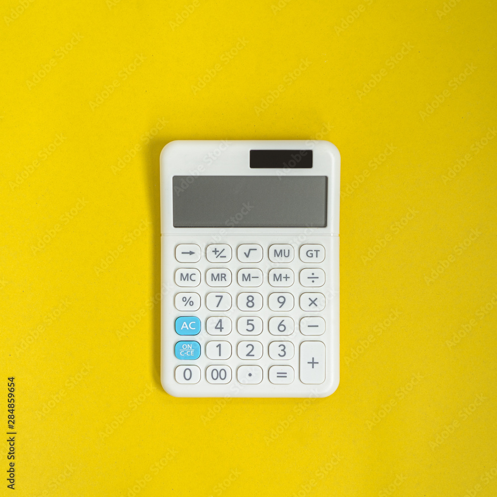 White calculator on yellow background White calculator on yellow background
