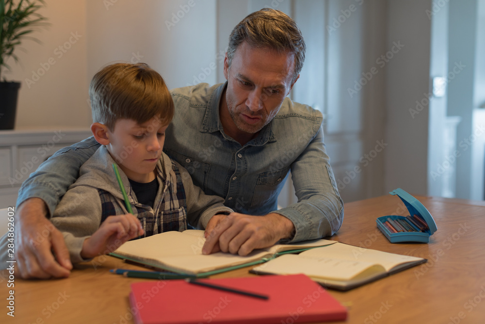 Father helping his son with his homework Father helping his son with his homework