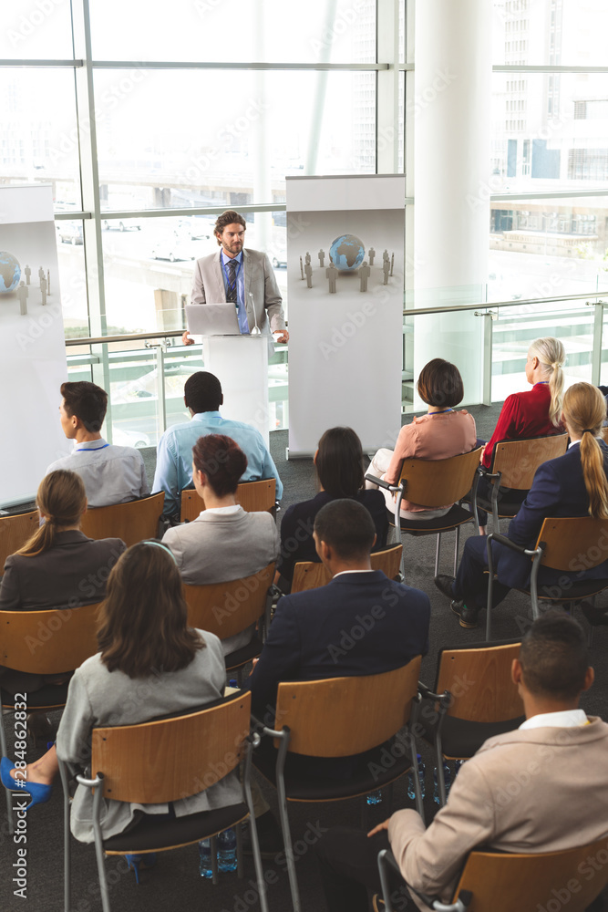Obraz premium Male speaker with laptop speaks in a business seminar