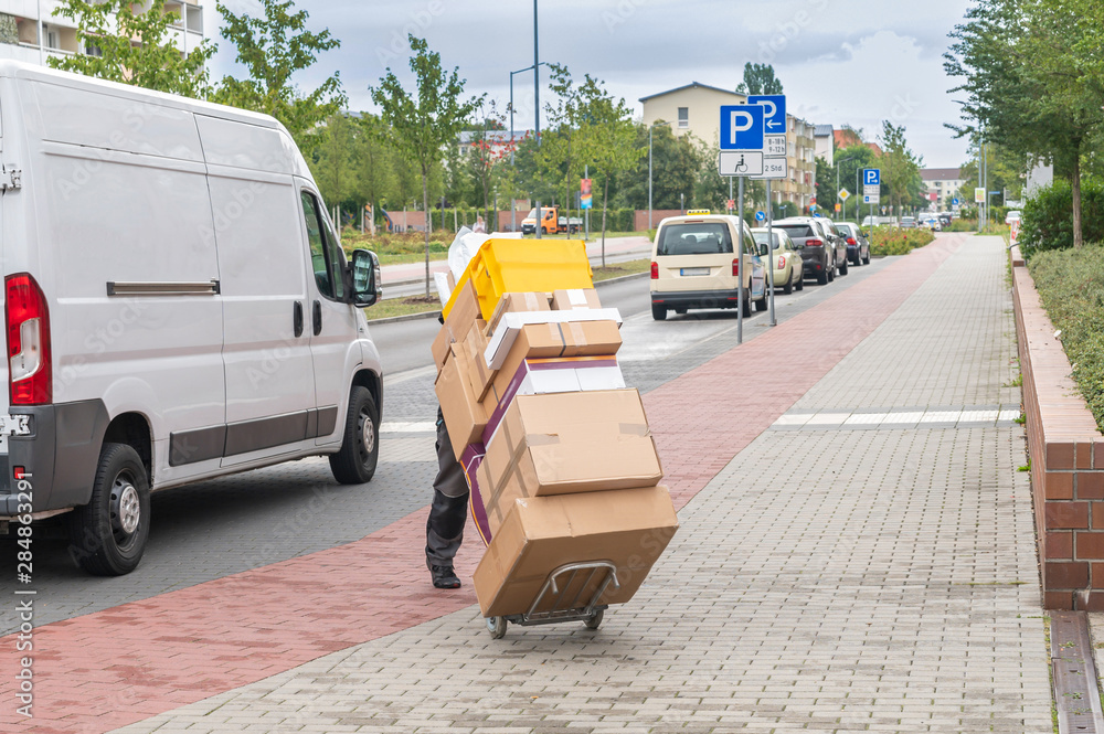 Ein Angestellter eines Paketdienstes liefert Pakete aus