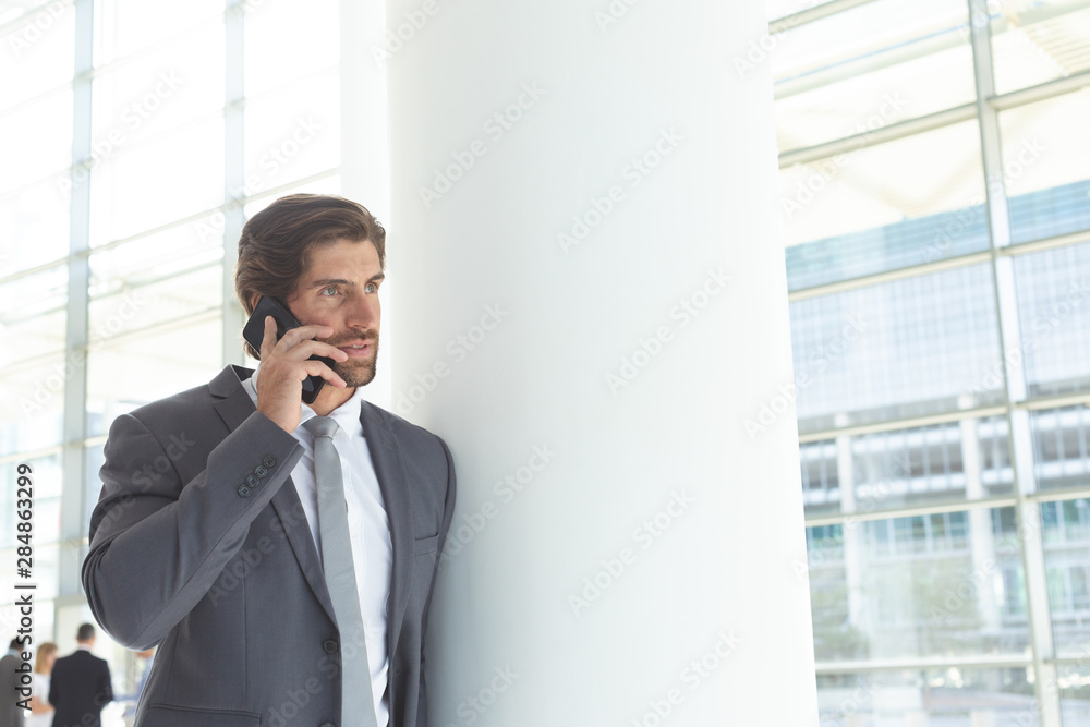Businessman talking on mobile phone in lobby office Businessman talking on mobile phone in lobby office