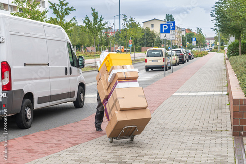 Obraz na płótnie Ein Angestellter eines Paketdienstes liefert Pakete aus w salonie