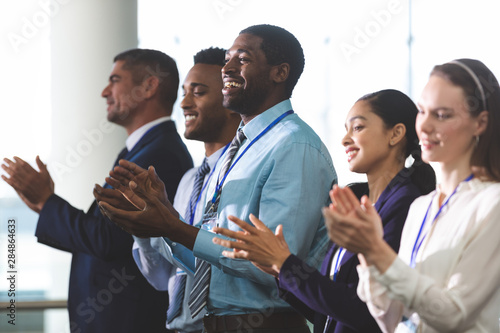 Happy business people applauding in a business seminar