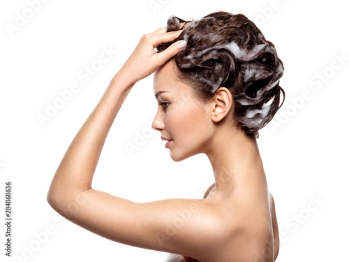 Beautiful woman soaping the brown hair