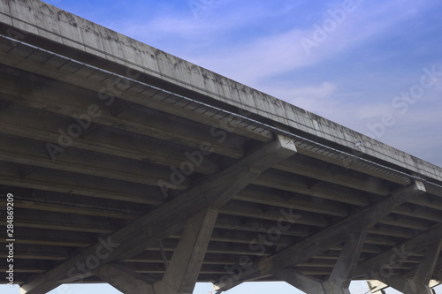 Under view of overpass or toll way on blue sky background