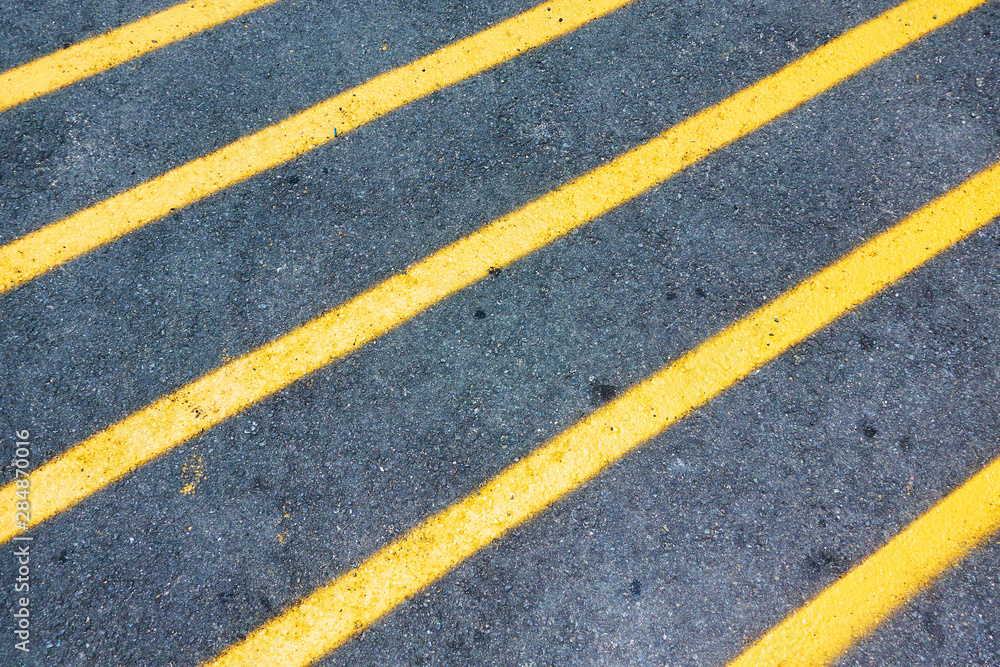 Yellow diagonal lines marking on asphalt road Yellow diagonal lines marking on asphalt road