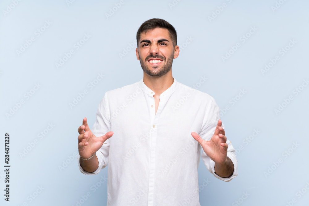 Handsome man with beard over isolated blue background frustrated by a bad situation Handsome man with beard over isolated blue background frustrated by a bad situation