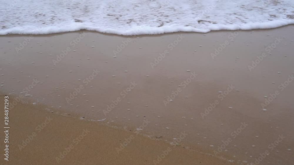 Calm evening ocean surf. Foamy waves fill the sandy beach. The concept of calm and pacification Calm evening ocean surf. Foamy waves fill the sandy beach. The concept of calm and pacification