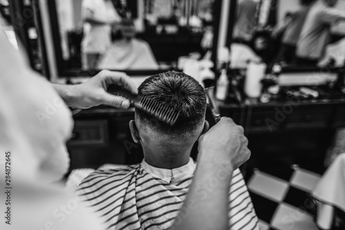 Men's haircut. Haircut with scissors. Black and white photo.