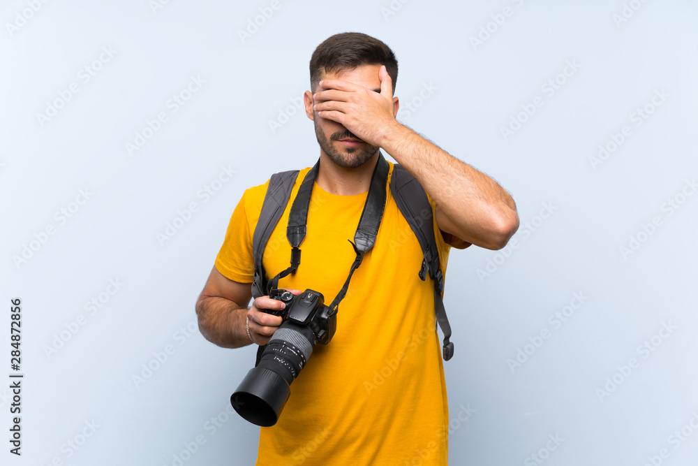 Young photographer man covering eyes by hands Young photographer man covering eyes by hands