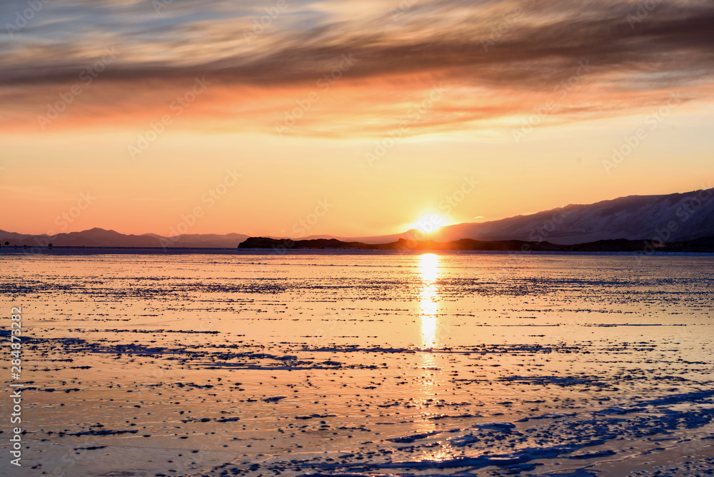 Colorful sunset over the crystal ice of Baikal lake