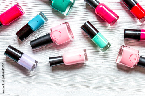 lot of bottles nail polish on wooden background top view